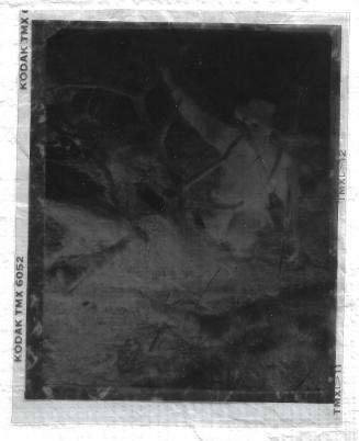 Untitled-negative of Carl Rungius holding a gun with a dead elk.