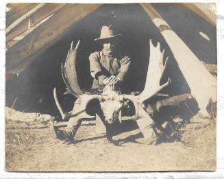 B&W photo of Rungius in front of a tent
