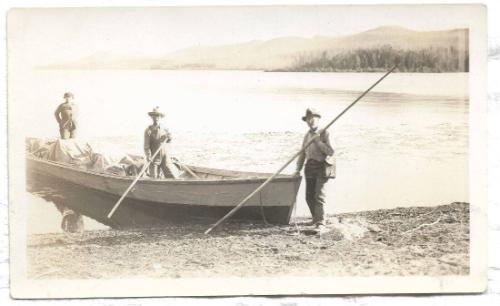 Untitled-two men and one woman in a boat by a lakeshore